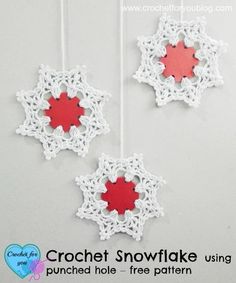 two crochet snowflake ornaments hanging from strings