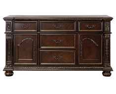 a large wooden dresser with ornate carvings on the top and bottom, in dark wood