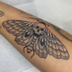 a close up of a person's arm with a butterfly tattoo on it