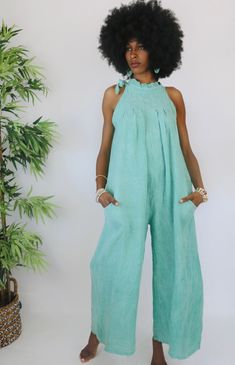 She's a truly stunning jumpsuit! Made of fine Italian linen, she's a casual dream. Attend a beach wedding or day cruise with her and she will not disappoint. The tie neckline with pleating is all the detail you need to look effortless chic. This jumpsuit is made from a breathable linen material that is sure to make you feel comfortable and stylish. Don't forget the wide leg design that allows you to glide in comfort throughout your day. She's a free size... fitting Small, Medium and Large comfor Linen Jumpsuit For The Beach, Chic Linen Jumpsuits And Rompers For Beach, Elegant Linen Jumpsuits And Rompers For Beach, Chic Relaxed Fit Jumpsuits And Rompers For Vacation, Linen Jumpsuit, Linen Material, Leg Design, Effortless Chic, Olympia