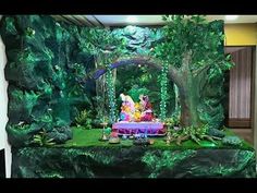 an image of a stage set up in the middle of a room with green plants and trees