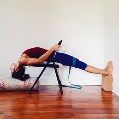 a woman laying on a chair with her legs up and holding a remote in one hand