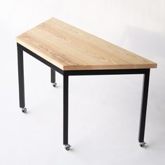 a wooden table sitting on top of a metal frame with two wheels attached to it