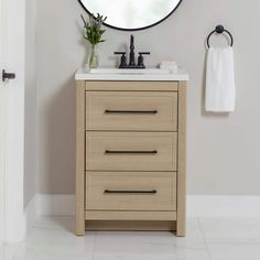 a bathroom vanity with a round mirror above it and a white towel hanging on the wall