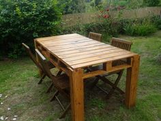 a wooden table and chairs sitting in the grass