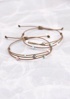 Nothing says aloha quite like our pearl and larimar stone riptide bracelets. 
Our rope jewelry was originally inspired from our 7 years of living in Hawaii. Tula Blue has been spun up with strength, endurance and always the goal of tying kindred souls together. 

Adjustable one-size-fits-all waterproof bracelets are meant for adventure! And this Aloha Riptide bracelet is one of our best-selling bracelets! You just have to pick your pearls! White or blush and each comes with a mermaid pearl. Minimalist Beaded Bracelets With Adjustable Length For Beach, Minimalist Beaded Bracelets For The Beach, Adjustable Beachy Beaded Bracelets For Everyday, Beachy Bracelet With Sliding Knot, Minimalist Adjustable Beaded Bracelets For Beach, Adjustable Ocean-inspired Jewelry For Everyday, Minimalist Resizable Bracelets For Beach, Everyday Adjustable Ocean-inspired Jewelry, Adjustable Ocean-inspired Everyday Jewelry