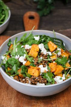 a salad with lettuce, carrots and feta cheese in a bowl