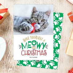 a christmas card featuring a cat playing with a toy