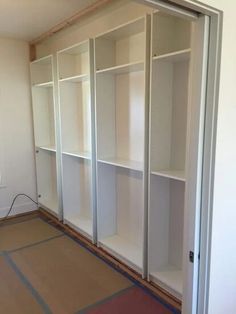 an empty room with some white shelves in it