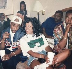 a group of people sitting next to each other on a couch with cups in their hands