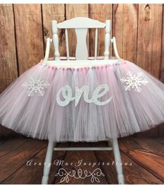 a pink and white tutule with snowflakes on it, sitting in front of a wooden wall