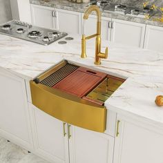 a kitchen with marble counter tops and gold faucets on the sink's side