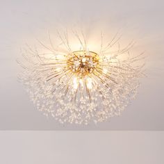 a chandelier hanging from the ceiling in a room with white walls and flooring