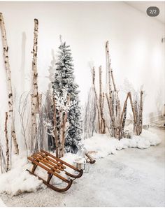 a room with snow covered trees and a wooden bench in the foreground, surrounded by fake snow