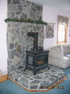 a living room with a stone fireplace and blue carpet