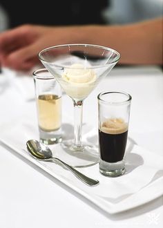 two glasses filled with ice cream sitting on top of a white table