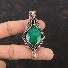 Note : Due to the natural formation of this gemstone. Slight variation in design and color are to be expected. Malachite Gemstone Pendant Copper Wire Wrapped Pendant Malachite Jewelry Gift For Mom Handmade Pendant Copper Wire Jewelry Stylish Pendants Handmade Copper Pendant SKU : VFWP-1186 Gemstone : Malachite Stone Shape : Oval     Metal Purity : Copper Pendant Length : 70 MM   Pendant Width : 33 MM There are many benefits associated with Malachite such as providing protection, alleviating negativity, and physically helping to enhance overall well-being like your immune system, your respiratory system, your liver, and your energy levels. Green Gemstones With Stone Setting For Gifts, Green Cabochon Gemstones For Jewelry Making, Green Agate Beads For Jewelry Making, Artisan Malachite Gemstone Jewelry, Handmade Green Gemstones For Jewelry Making, Green Agate Gemstones For Jewelry Making, Green Natural Stones For Jewelry Making, Green Agate Gemstone Beads, Green Agate Gemstones With Beads