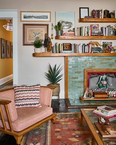 a living room filled with furniture and bookshelves next to a fire place covered in books