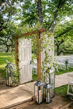 an outdoor ceremony set up with white chairs and greenery