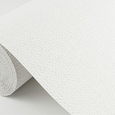 white textured paper on the wall with a roll of tape in front of it