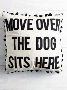 a black and white pillow with the words move over the dog sits here on it