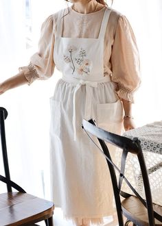 a woman standing next to a chair in front of a window