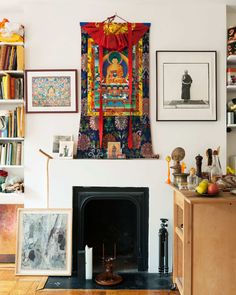 a living room with a fire place and pictures on the wall above it's fireplace