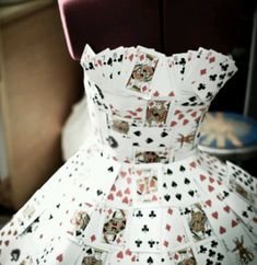 a dress made out of playing cards sitting on top of a mannequin