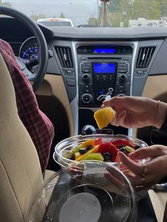 two people are eating fruit in the car