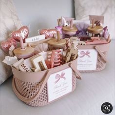 two baskets filled with personal care items on top of a white table covered in pink ribbon