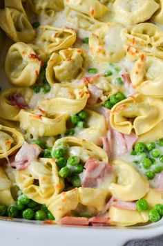 pasta with peas and ham in a white casserole dish