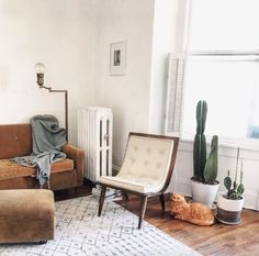 a living room with two couches and a radiator next to a window