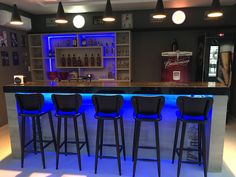 a bar with four stools in front of it