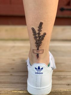 a woman's foot with a flower tattoo on the lower part of her leg