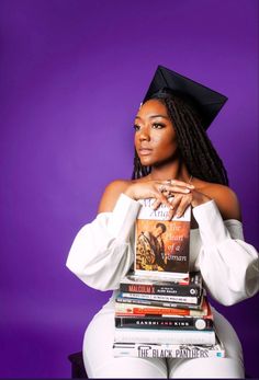 a woman sitting on top of a stack of books