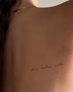 the back of a woman's shoulder with writing on it