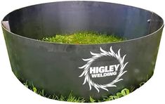 a large metal planter with grass in it's center and logo on the side