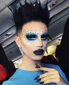 a woman with black and blue makeup on an airplane