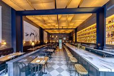 an empty restaurant with checkered flooring and bar seating