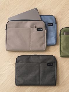 four different colored pouches sitting on top of a wooden floor next to each other