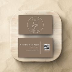 a business card on a wooden plate with a qr code in the middle and a white circle around it