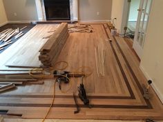 a living room with hard wood flooring and tools laying on the floor next to it