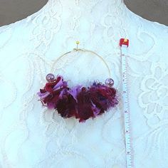 a close up of a person wearing a white dress with purple flowers on it and a measuring tape