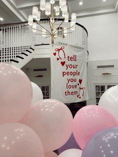 balloons are in front of a banner that says tell your people you love them