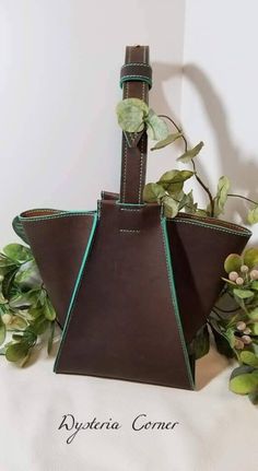 This is a hand-made hobo bag.  It is a unique shape and style.  The leather is 5-6 oz. thick.  It is beautiful brown leather with some teal accent.  This purse is fully hand stitched. Brown Bucket Bag With Leather Lining, Brown Bucket Bag With Leather Lining And Top Handle, Brown Top Handle Bucket Bag, Brown Satchel With Leather Backing And Top Handle, Brown Leather Handheld Bucket Bag, Brown Satchel Hobo Bag With Handle Drop, Brown Top Handle Hobo Bag, Brown Handheld Bucket Bag For Everyday Use, Brown Everyday Handheld Bucket Bag