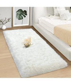 a white rug on the floor in a room with a bed and two candles next to it