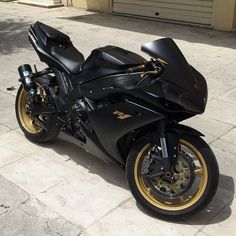 a black motorcycle parked on top of a sidewalk