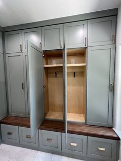 an empty walk in closet with drawers and cupboards on each side, two doors open