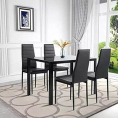 a dining room table and chairs in front of a large window with an area rug on the floor