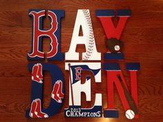 the word bayden is made up of baseball related letters on a wooden floor with other sports memorabilia